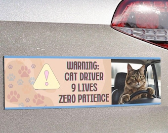 Peut inclure: Autocollant rectangulaire pour pare-chocs de voiture avec une bordure bleu clair et un fond pêche. Le côté gauche présente des empreintes de pattes et un panneau d'avertissement jaune. Le côté droit montre un chat conduisant une voiture. Le texte indique : "ATTENTION : CHAT CONDUCTEUR 9 VIES ZÉRO PATIENCE."