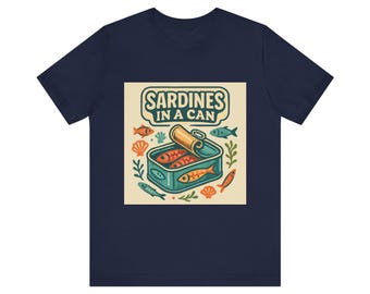 Peut inclure: T-shirt bleu marine avec une illustration de sardines en boîte. Le dessin montre une boîte de conserve turquoise avec un couvercle ouvert, des poissons oranges et le texte "Sardines in a Can". Des poissons et des algues entourent le dessin.