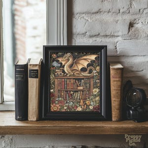 May include: A framed print featuring a golden dragon perched atop a bookshelf filled with books, surrounded by flowers. The artwork is in a black frame and is displayed on a wooden shelf with vintage books.
