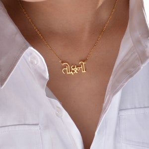 May include: A gold chain necklace with a pendant that says "Tishani" in Hindi script.