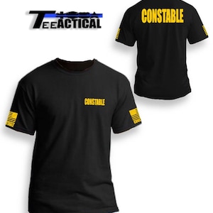 May include: Black t-shirt with the word "CONSTABLE" printed in yellow on the front and back. The shirt has a thin yellow stripe on the sleeves.