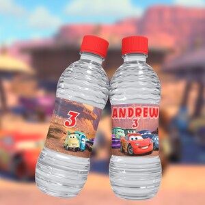 Pode incluir: Duas garrafas de &aacute;gua de pl&aacute;stico transparente com tampas vermelhas e etiquetas personalizadas com personagens de Cars. As etiquetas t&ecirc;m o n&uacute;mero "3" e o nome "Andrew".