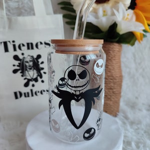 May include: A clear glass jar with a bamboo lid and a black and white graphic of Jack Skellington from The Nightmare Before Christmas. The jar has a straw sticking out of the lid. The jar is sitting on a white surface.
