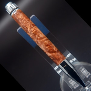 May include: A brown and silver pen with a wood grain pattern. The pen has a silver cap and a silver tip.