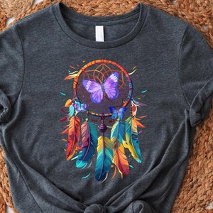May include: A dark gray t-shirt with a colorful dreamcatcher design featuring a purple butterfly. The dreamcatcher has feathers in shades of blue, green, yellow, orange, and red.