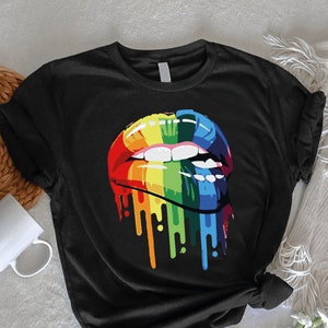 May include: Black t-shirt with a rainbow-colored dripping lips graphic.
