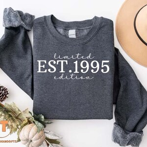 May include: A dark gray sweatshirt with white text that reads "limited EST. 1995 edition".