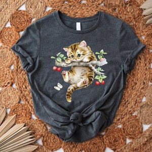 a t - shirt with a cat laying on top of it