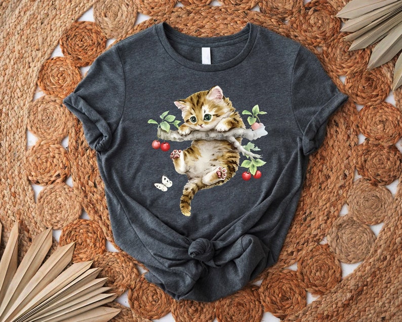 a t - shirt with a cat laying on top of it