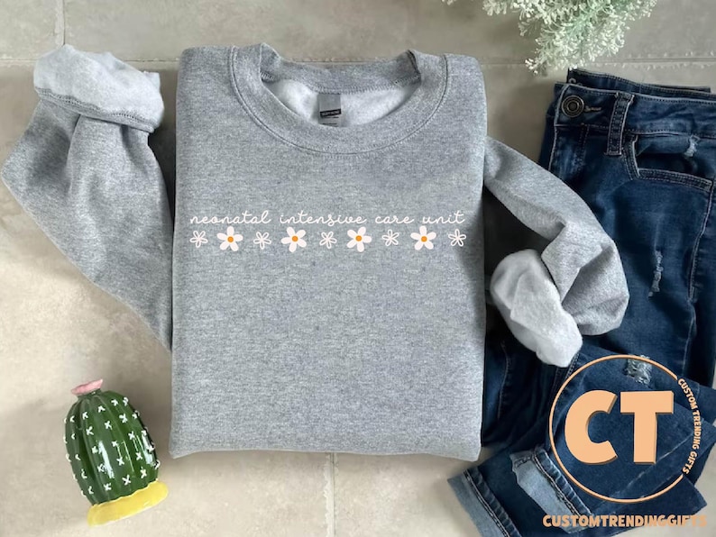 a sweater with flowers on it next to a cactus