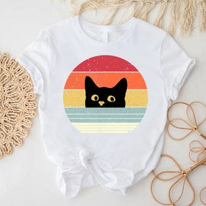 a white shirt with a black cat on it