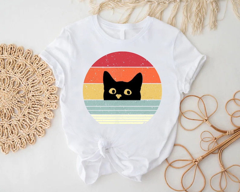 a white shirt with a black cat on it