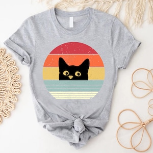 a t - shirt with a black cat on it