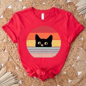a red shirt with a black cat on it