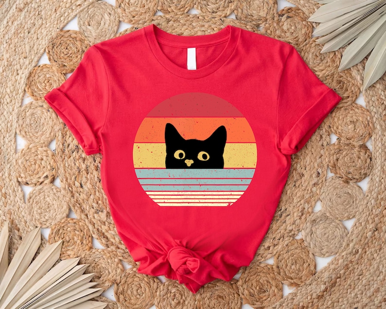 a red shirt with a black cat on it