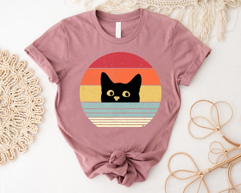 a t - shirt with a black cat on it