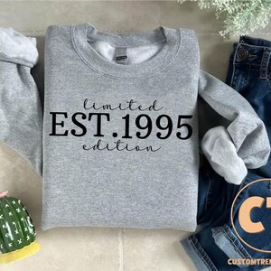 May include: Gray sweatshirt with the text "limited EST. 1995 edition" printed in black.