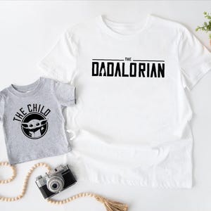 a t - shirt with the words the child and a camera next to it