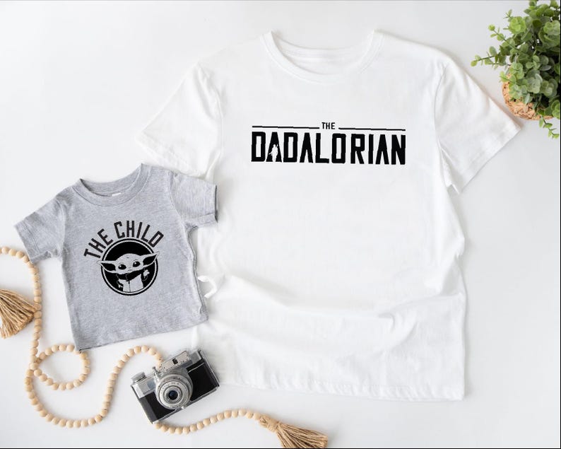 a t - shirt with the words the child and a camera next to it