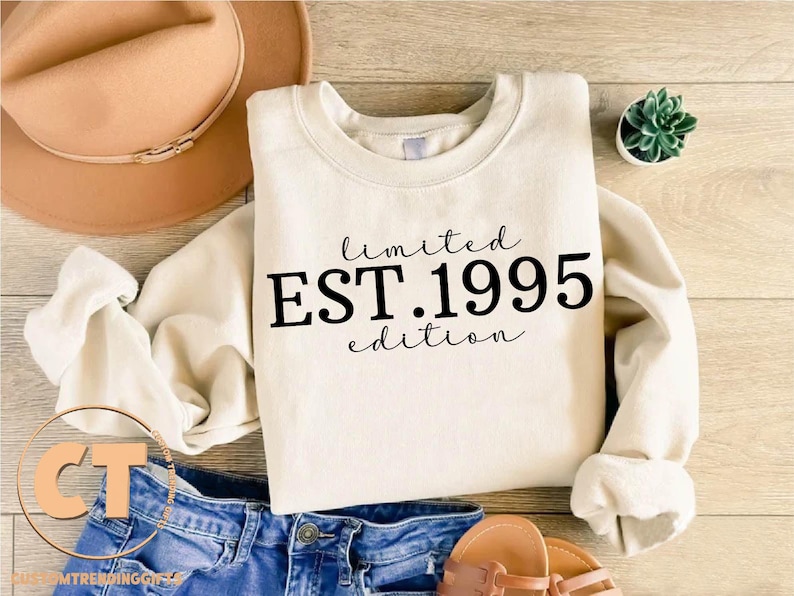 May include: A white crew neck sweatshirt with the text "limited EST.1995 edition" printed in black.