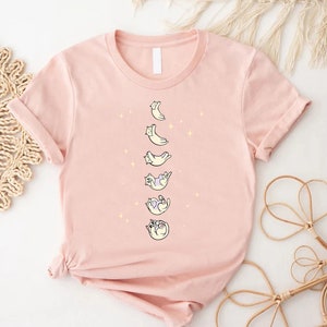 a pink t - shirt with cats and moon on it