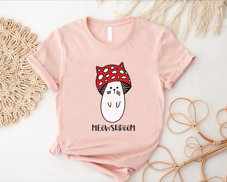 a pink shirt with a cartoon character wearing a red bow