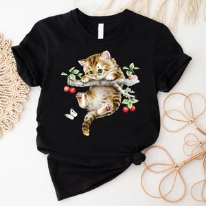 a t - shirt with a picture of a cat and a butterfly on it