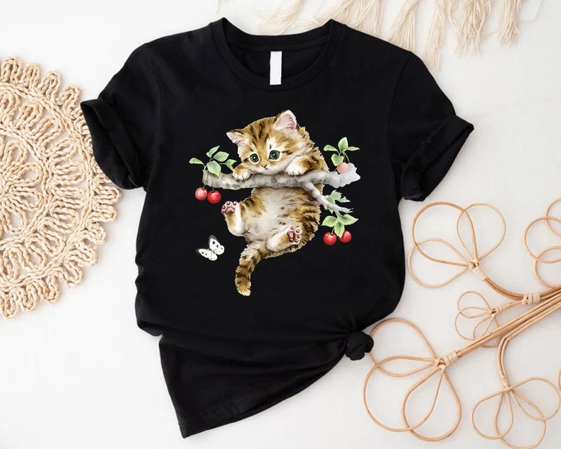 a t - shirt with a picture of a cat and a butterfly on it