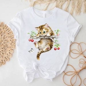 a white t - shirt with a picture of a cat on it