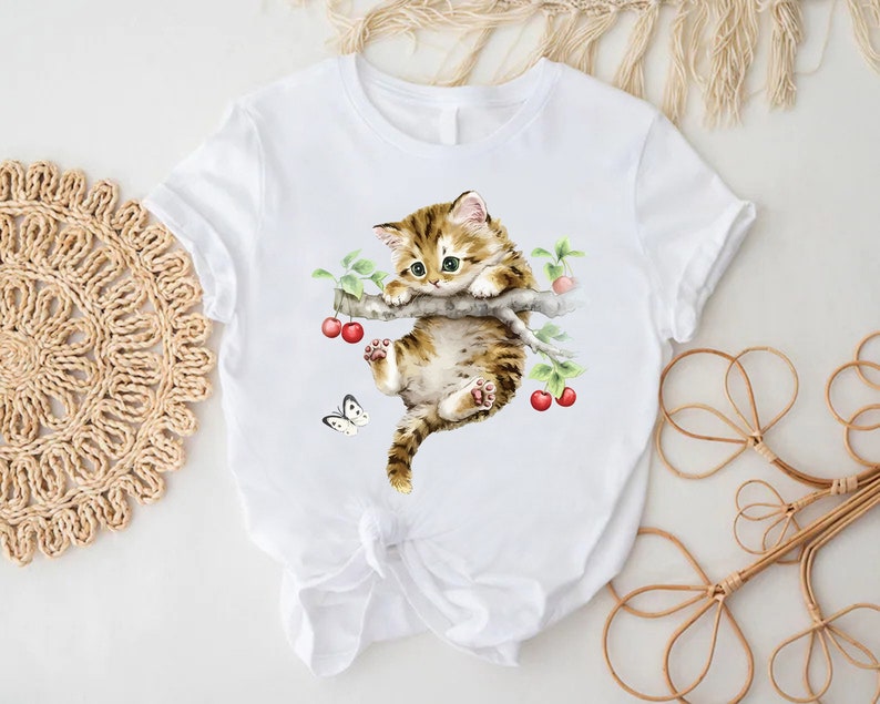 a white t - shirt with a picture of a cat on it