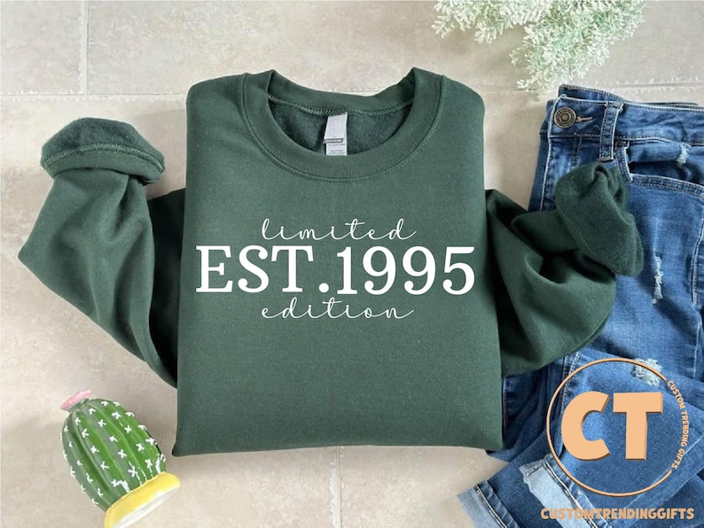 May include: A dark green sweatshirt with white text that reads "limited EST. 1995 edition".