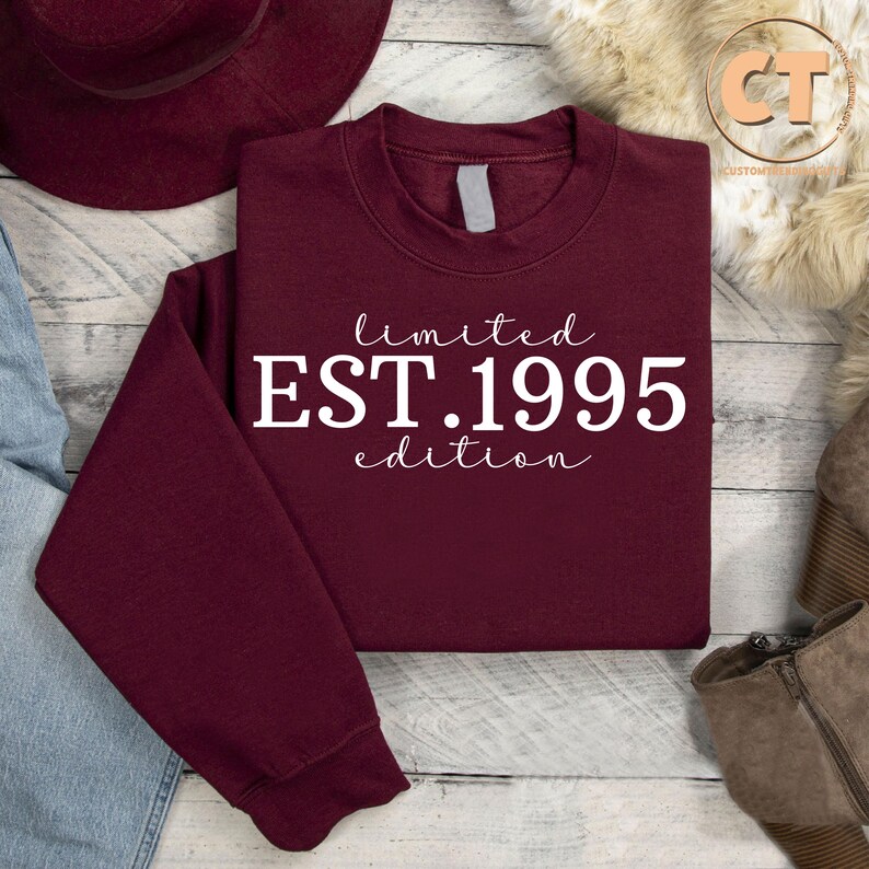 May include: Burgundy sweatshirt with white text that reads "limited EST. 1995 edition".