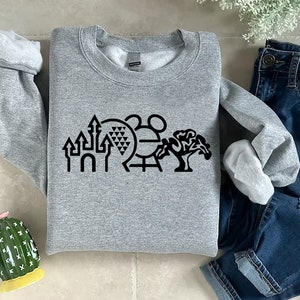 K&ouml;nnte beinhalten: Ein graues Sweatshirt mit einer schwarzen Grafik der ikonischen Disney World-Sehensw&uuml;rdigkeiten, darunter das Schloss von Aschenputtel, Spaceship Earth, Mickey Mouse und ein Baum.