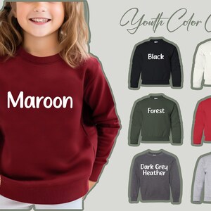 a girl wearing a maroon sweatshirt with the name maroon on it