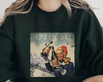 Könnte beinhalten: Dunkelgrünes Sweatshirt mit einem Grafik im Vintage-Stil. Die Grafik zeigt eine Frau in einem blauen Mantel und orangefarbener Mütze, die Champagnerflaschen hält, mit dem Text "APRES SKI" darüber. Der Hintergrund zeigt eine schneebedeckte Berglandschaft.