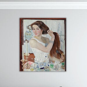 May include: A framed painting depicts a woman with brown hair arranging her hair. She wears a white dress and a silver bracelet. A candle and various bottles are on a table in front of her. The painting has a warm color palette.