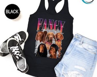 May include: Black tank top with a graphic of four Vizsla dogs and the word "FANCY" in pink and purple letters. The dogs are all looking at the camera.