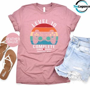 a pink shirt with a video game controller on it