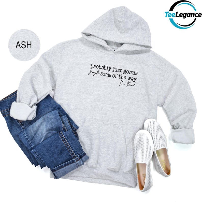 A gray hoodie with the text "probably just gonna play some of the way Jim fed" printed on it, along with a pair of blue jeans and white slip-on shoes.