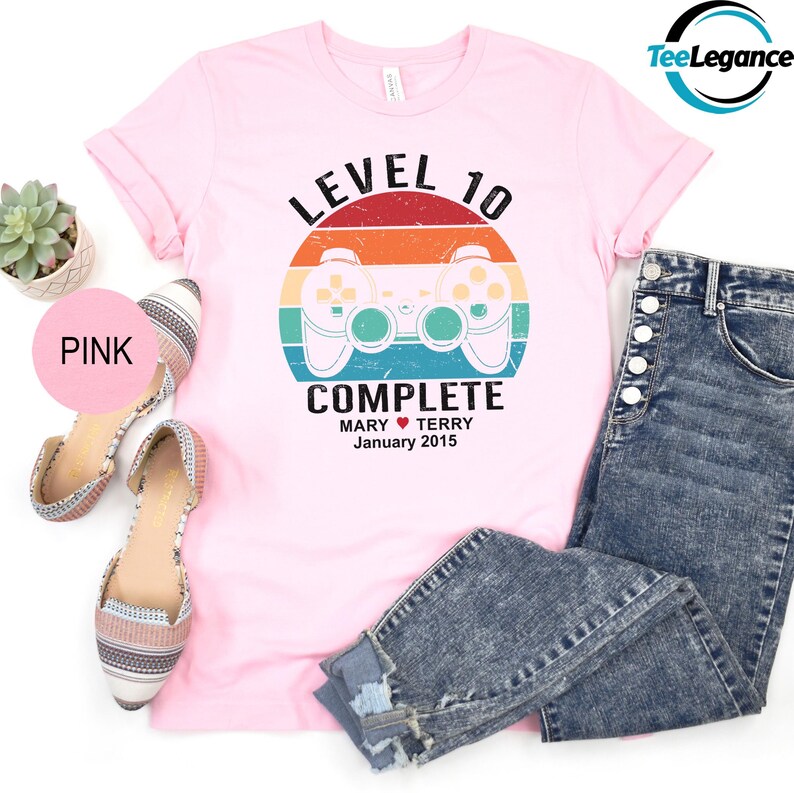 a pink shirt with a video game controller on it