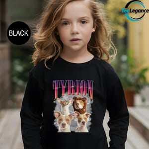 a little girl wearing a black shirt with a picture of a dog on it