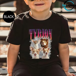 a little boy sitting on a bench wearing a t - shirt with a picture of