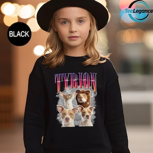 a young girl wearing a black sweatshirt with a picture of two dogs on it