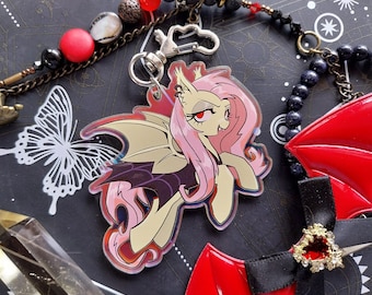 May include: A pink and yellow cartoon character with bat wings and a red and black background. The character has a pink mane and tail and is wearing a black dress. The character is a vampire.