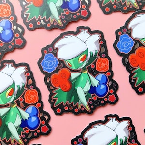 May include: A collection of stickers featuring a green and white character with red eyes, surrounded by red, blue, and orange floral designs. The stickers have a black border and are set against a pink background.