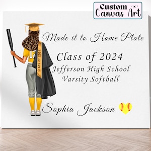 May include: A white canvas print with a black and yellow illustration of a softball player wearing a graduation cap and gown. The text "Made it to Home Plate" is written in cursive above the text "Class of 2024 Jefferson High School Varsity Softball Sophia Jackson".