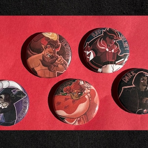 Op de afbeelding: Vijf ronde pins met illustraties van stripfiguren. De pins tonen personages met de labels "Brute", "Red Velvet", "Dark Choco", "Licorice" en een ander personage. De pins liggen op een rode ondergrond.