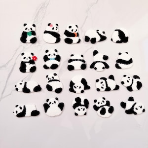 May include: A collection of 24 black and white panda bear felt patches in various poses. The patches are approximately 5 cm in size and are perfect for adding a touch of whimsy to crafts, clothing, or accessories.