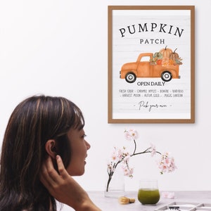 May include: A framed print with a rustic design. The artwork features an orange truck filled with pumpkins and fall foliage, with the words "Pumpkin Patch" at the top. Below the truck, the text reads "Open Daily" and a list of fall-themed items.