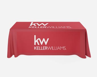 May include: Red table cover with the Keller Williams logo in white. The logo features the letters "kw" in a stylized font.